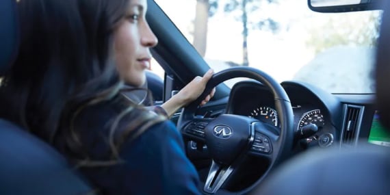 Interior View of Woman In An INFINITI Vehicle Equipped With InTouch Voice Features