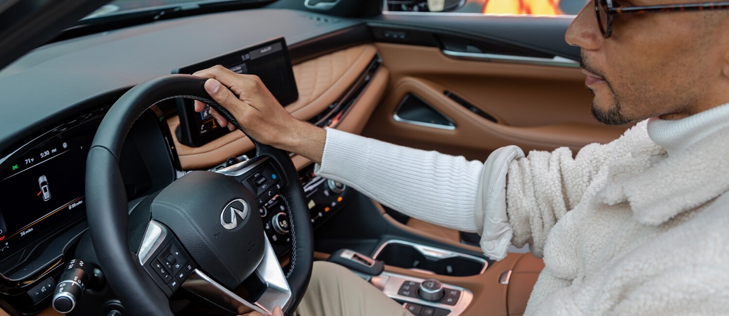 Image of man sitting in driver seat of the 2023 INFINITI QX60 Crossover SUV