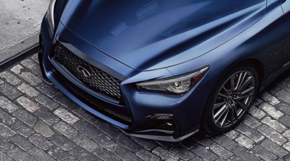 Close up of 2023 INFINITI Q50 exterior highlighting hood and front fascia