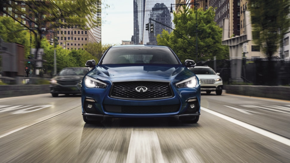 2024 Blue Q50 front grill driving on downtown city street