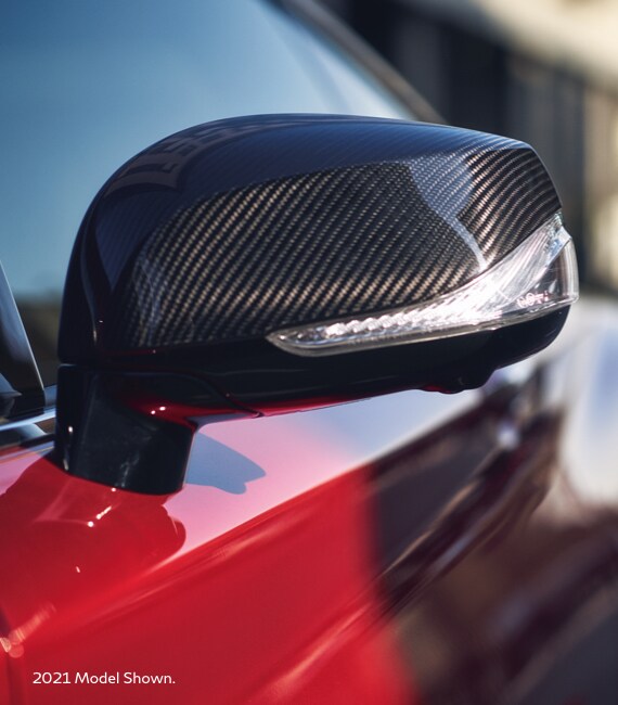 Close up of 2022 INFINITI Q60 side mirror highlighting carbon fiber trim