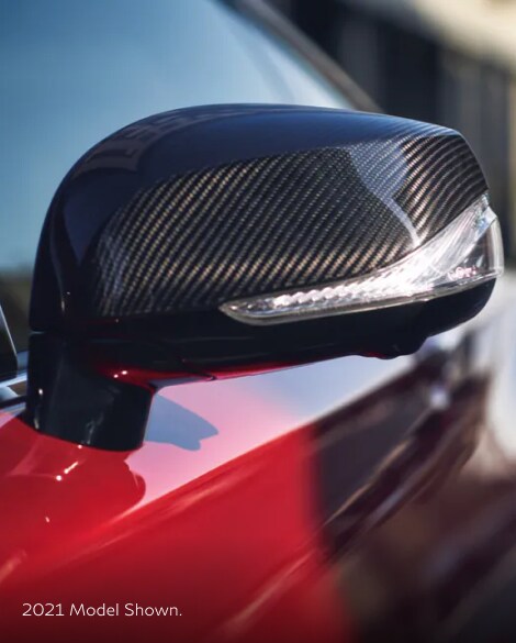 Close up of 2022 INFINITI Q60 side mirror highlighting carbon fiber trim