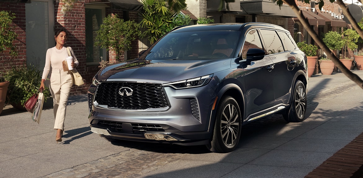 Woman walking in front of the 2022 INFINITI QX60 Crossover SUV