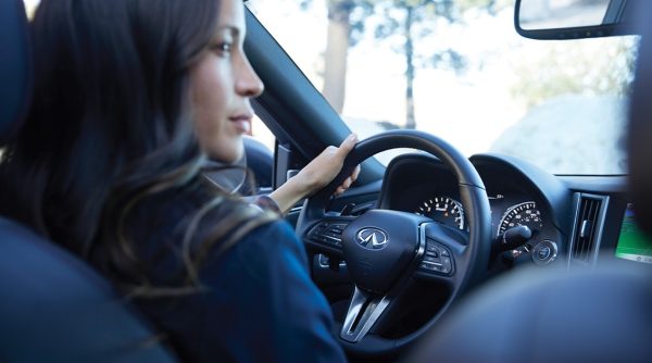 INFINITI InTouch Features | Interior View of Woman In An INFINITI Vehicle Equipped With InTouch Voice Features